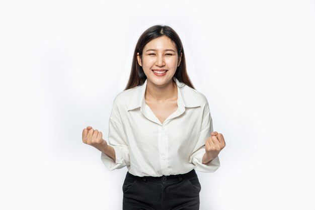 The woman wore a white shirt and dark trousers and made a fun pose