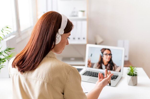 Woman at work having video call on laptop