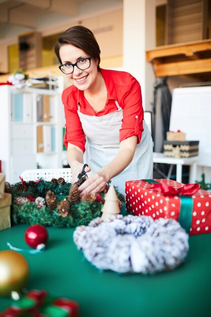 woman at work, making a Christmas wreath and wrapping gifts