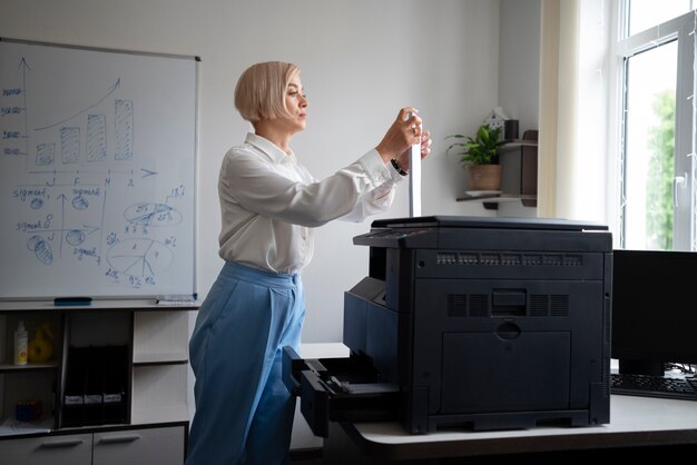 Woman at work in the office using printer