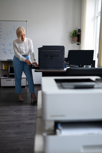 Donna al lavoro in ufficio utilizzando la stampante