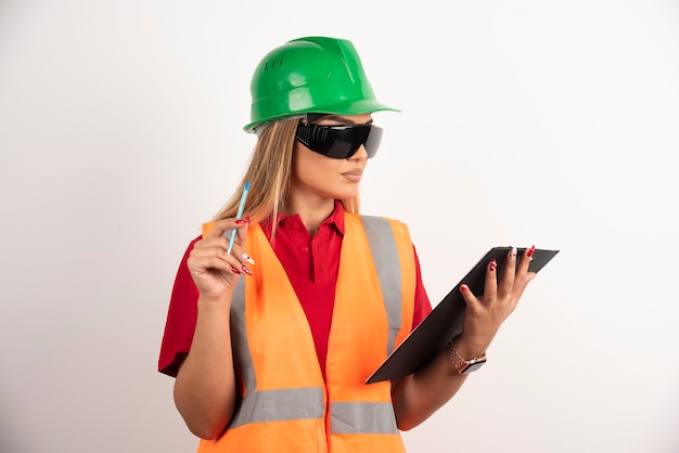 Woman worker holding a pencil with clipboard.