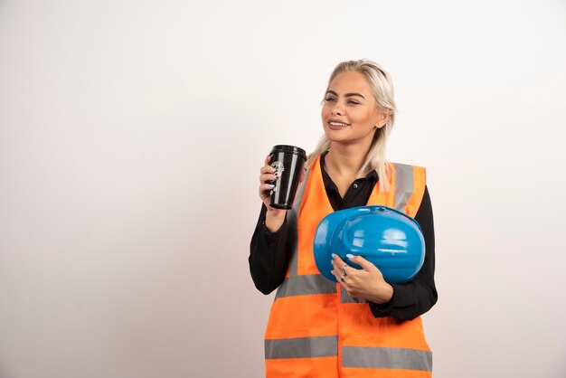 Woman worker posing with cup of coffee on white background. High quality photo