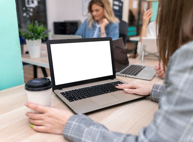 Woman working at a blank laptop