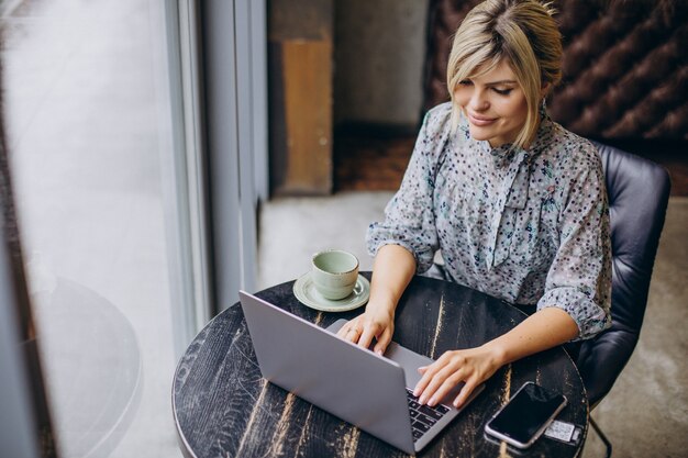 Woman working on computer and drinking coffee