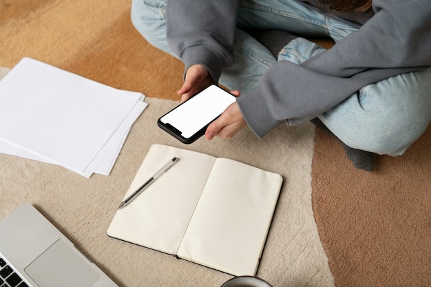 Woman working on the floor from home with device