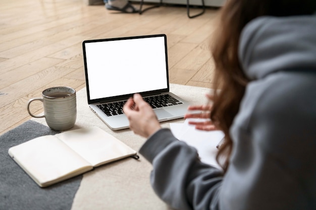 Woman working on the floor from home with device