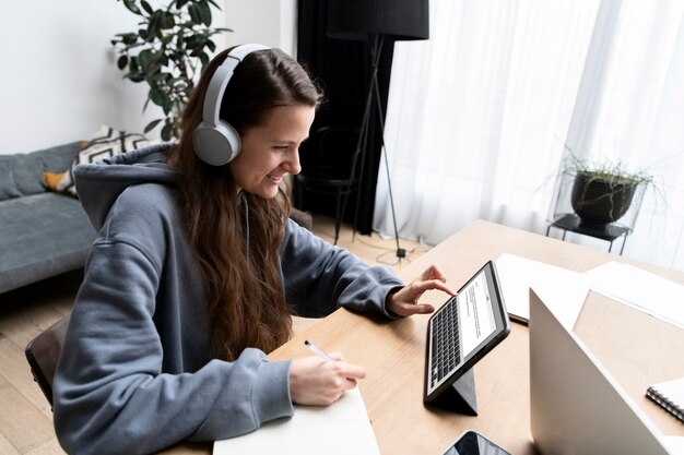 Woman working from home at desk with tablet