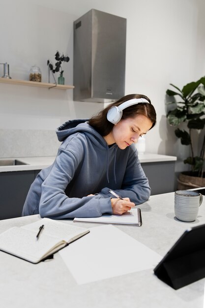 Woman working from home kitchen with tablet