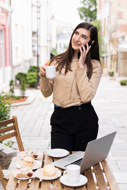 Woman working and having coffee outdoors