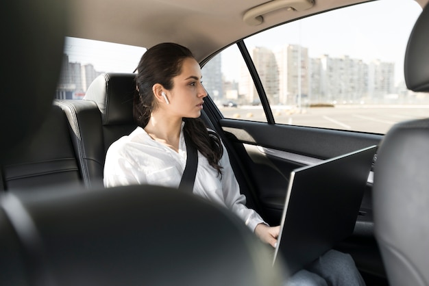 Woman working on her laptop in the car