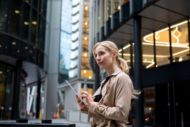 外でタブレットに取り組んでいる女性