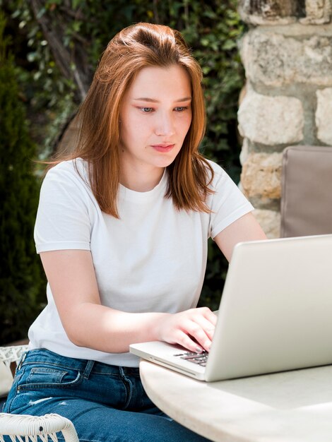 Бесплатное фото Женщина интенсивно работает на ноутбуке на открытом воздухе