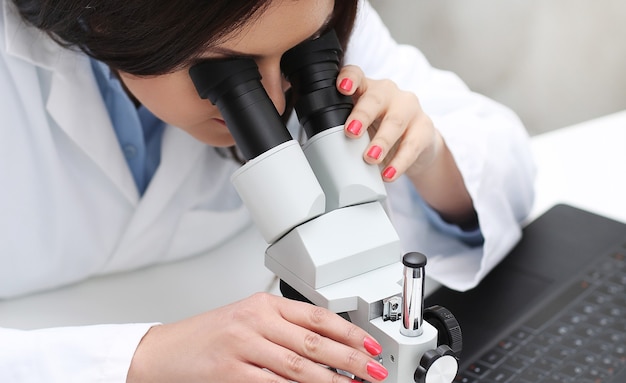 Woman working in the lab with a microscope