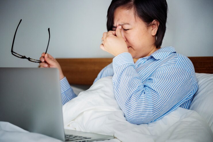 無料Photo ベッドでラップトップで働く女性