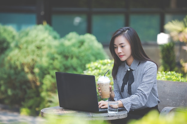 Женщина работает на ноутбуке в кафе и пить кофе