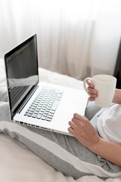 Woman working on laptop and drinking coffee