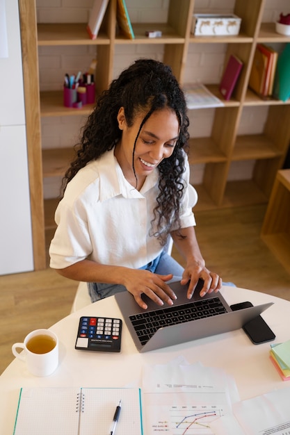 Free photo woman working on laptop high angle