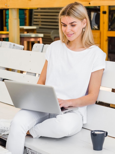 Woman working on laptop outdoors