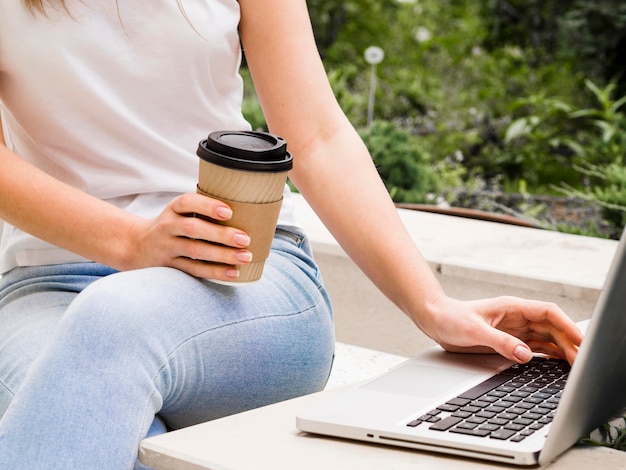 Woman working on laptop while having coffee