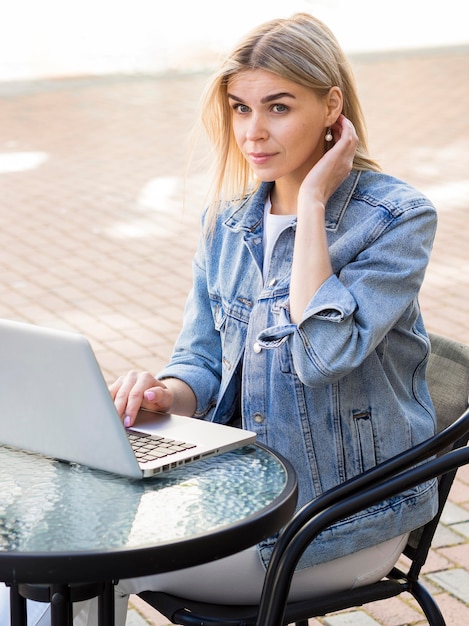 Free photo woman working on laptop while outside