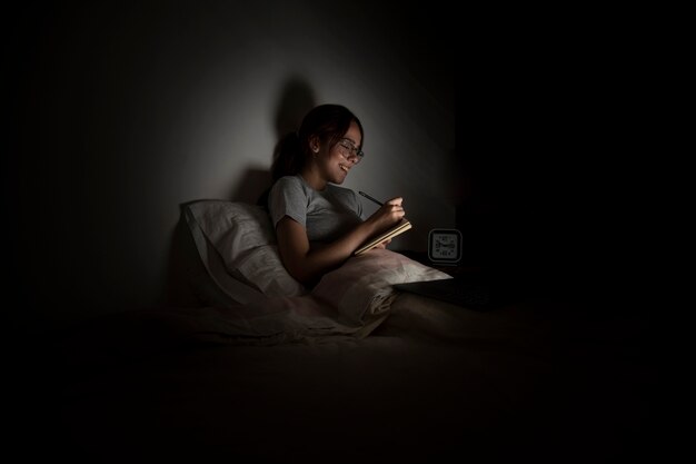 Женщина работает поздно дома в постели