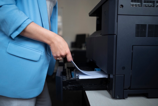 사무실에서 일하고 프린터를 사용하는 여성