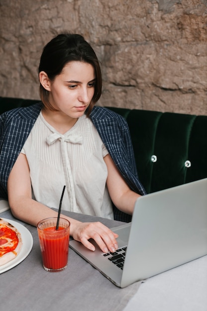 Бесплатное фото Женщина работает на ноутбуке в кафе