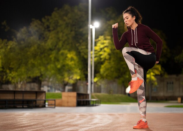 Woman working out at night full shot