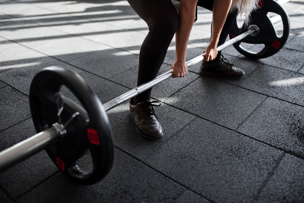 Donna che lavora con il bilanciere in palestra