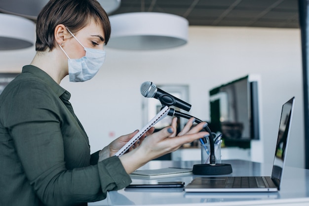 Woman working at record studio and wearing mask