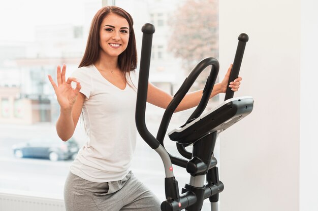 Woman working on stepper and showing ok sign