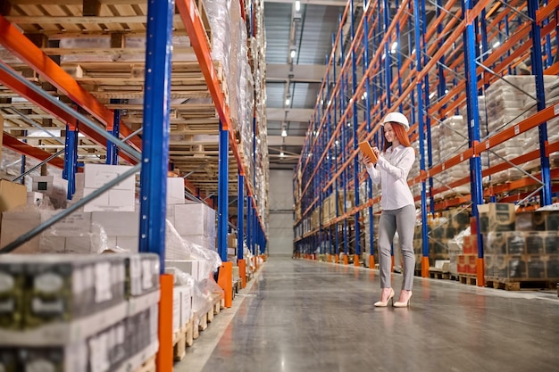 Free photo woman working on tablet standing in warehouse