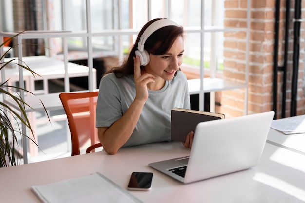 Woman working with headphones medium shot