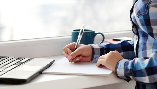 Woman writes in notebook