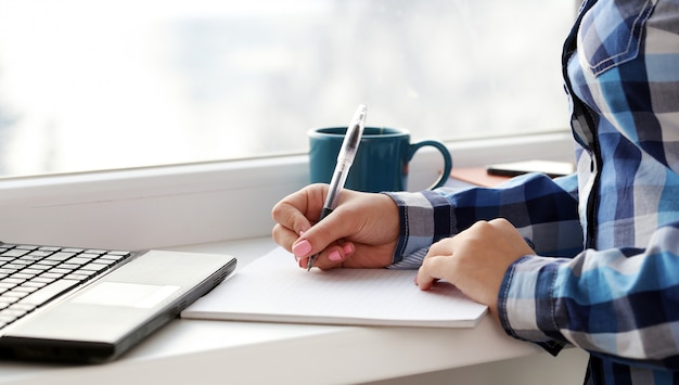 Woman writes in notebook