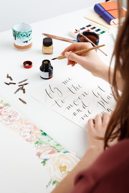 Woman writing calligraphy on postcards