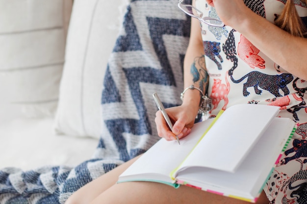 Woman writing in diary close up