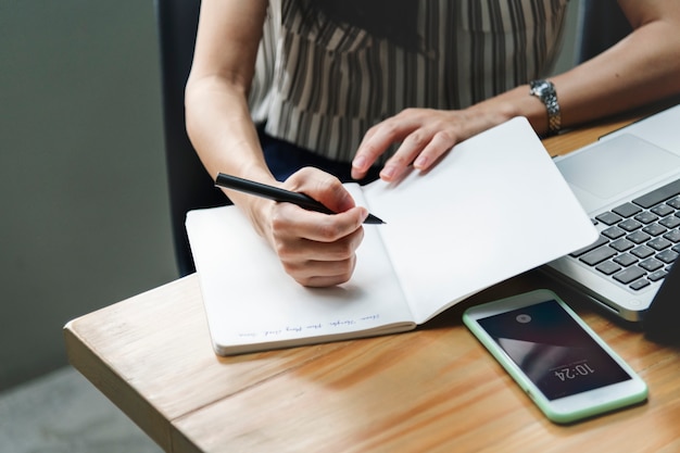 Foto gratuita donna che scrive in un taccuino