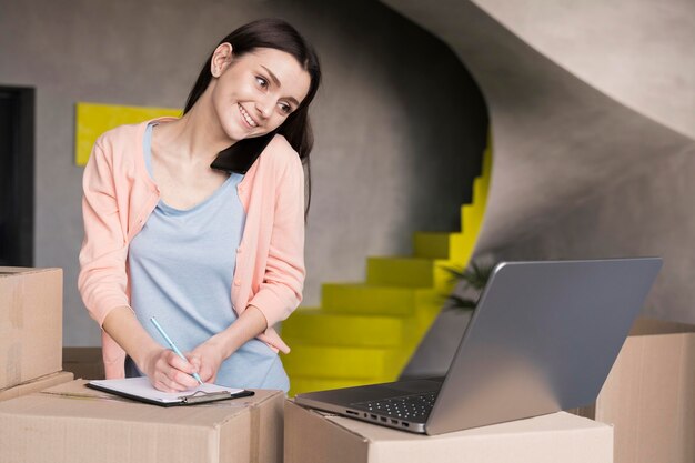 Woman writing orders from online shop to deliver