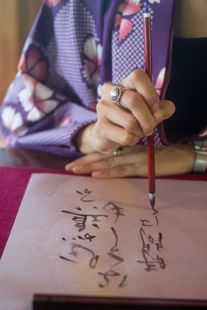 Free photo woman writing with ink on japanese paper