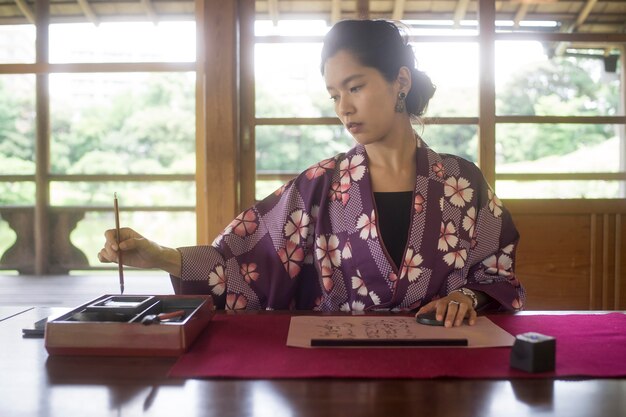 Foto gratuita donna che scrive con inchiostro su carta giapponese