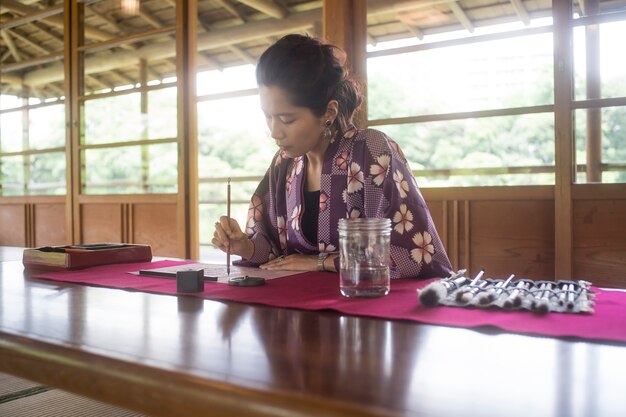 Женщина пишет тушью на японской бумаге