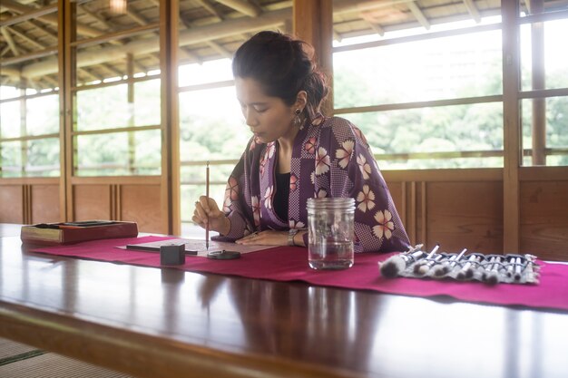 Woman writing with ink on japanese paper