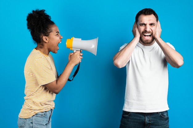 Woman yelling at man through megaphone