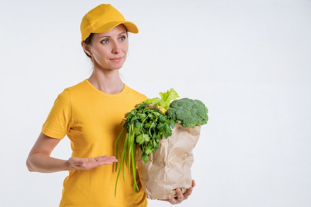 A woman in yellow clothes, delivering a package of food, on a white background