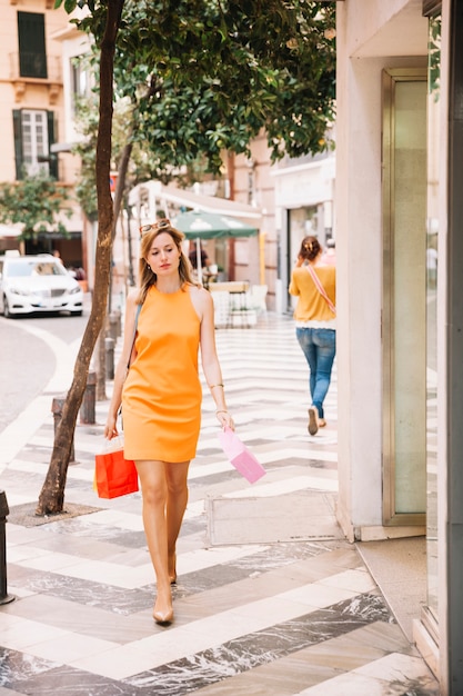 Donna in abito giallo shopping