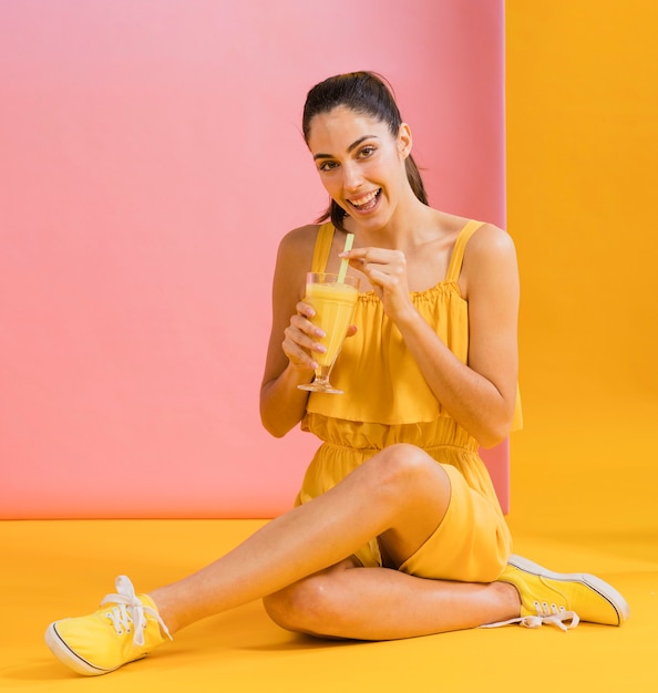 Woman in yellow dress with a glass of juice
