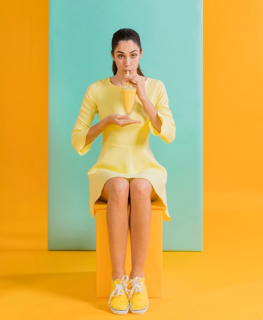 Free photo woman in yellow dress with juice