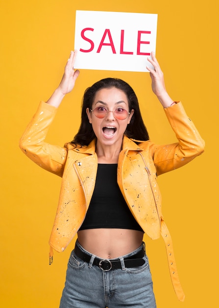 Woman in yellow jacket being surprised about the sales